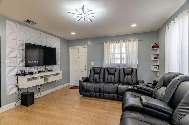 living room with light wood-style floors, baseboards, visible vents, and recessed lighting