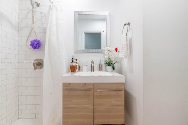 bathroom featuring a tile shower and vanity