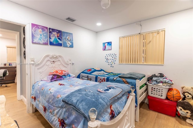 bedroom featuring wood finished floors, visible vents, and recessed lighting