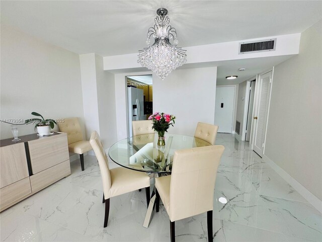 18071 Biscayne Blvd Unit 1503, Aventura, FL 33160 - dining area with light marble finish floors, baseboards, and a chandelier