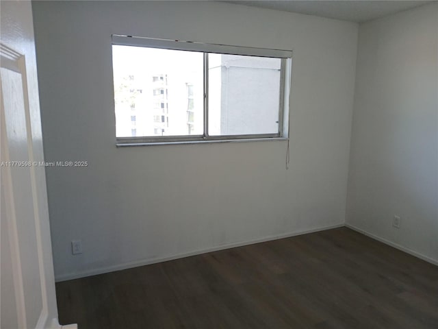 empty room with baseboards and wood finished floors