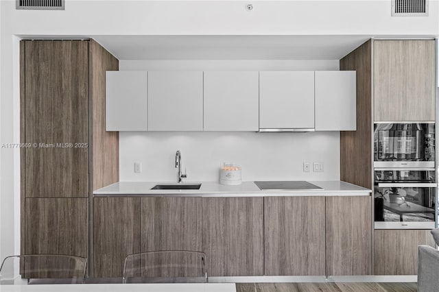 2900 NE 7th Ave Unit 1609, Miami, FL 33137 - kitchen featuring oven, modern cabinets, white cabinets, and light countertops