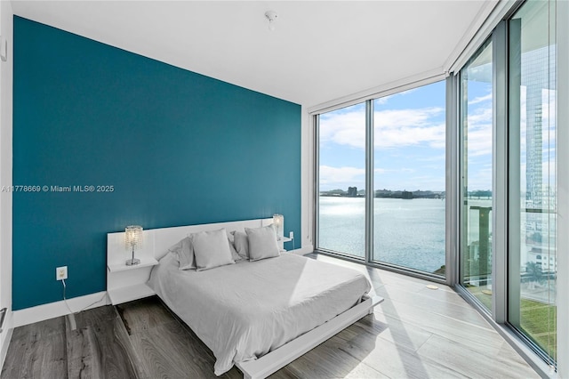 2900 NE 7th Ave Unit 1609, Miami, FL 33137 - bedroom featuring floor to ceiling windows, multiple windows, a water view, access to exterior, and wood finished floors