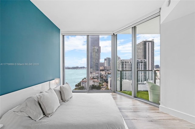 2900 NE 7th Ave Unit 1609, Miami, FL 33137 - bedroom with a skyline view, wood finished floors, expansive windows, and a water view