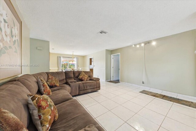 1625 E River Dr, Margate, FL 33063 - living area featuring a textured ceiling, light tile patterned floors, and baseboards