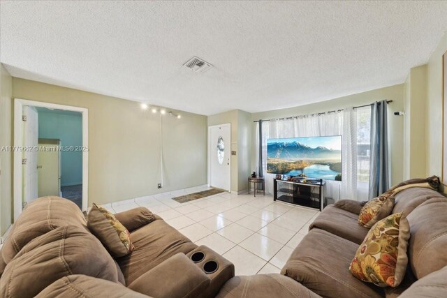 1625 E River Dr, Margate, FL 33063 - living room with light tile patterned floors, a textured ceiling, and baseboards