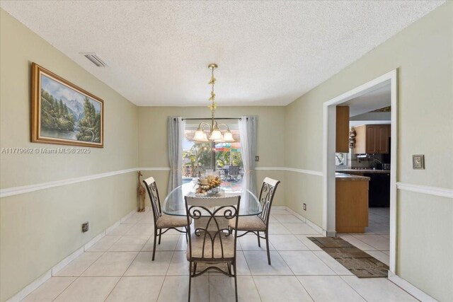 1625 E River Dr, Margate, FL 33063 - dining room with a chandelier, light tile patterned flooring, baseboards, and a textured ceiling