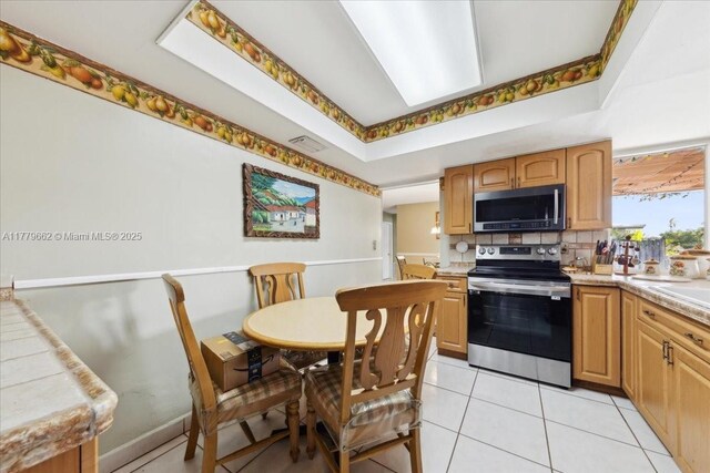 1625 E River Dr, Margate, FL 33063 - kitchen with appliances with stainless steel finishes, tasteful backsplash, light tile patterned floors, and light countertops
