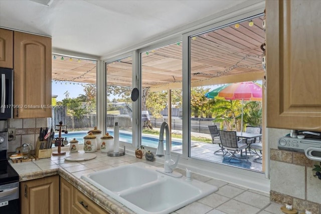 1625 E River Dr, Margate, FL 33063 - kitchen featuring stainless steel fridge, light tile patterned floors, glass insert cabinets, and light countertops