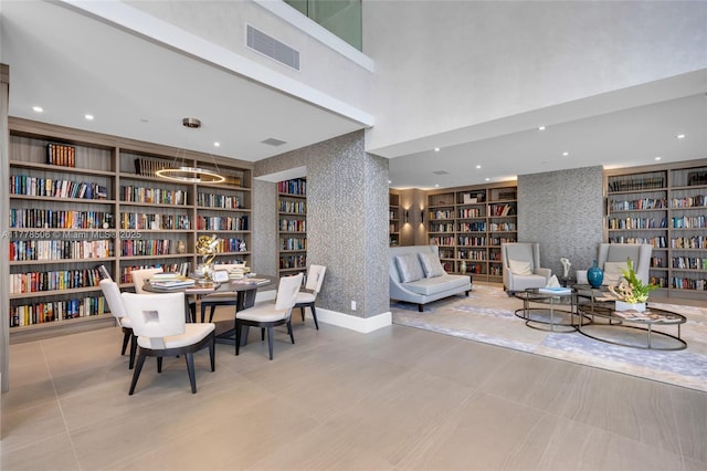 21150 NE 38th Ave Unit 2106, Aventura, FL 33180 - living area with baseboards, wallpapered walls, visible vents, bookshelves, and built in shelves