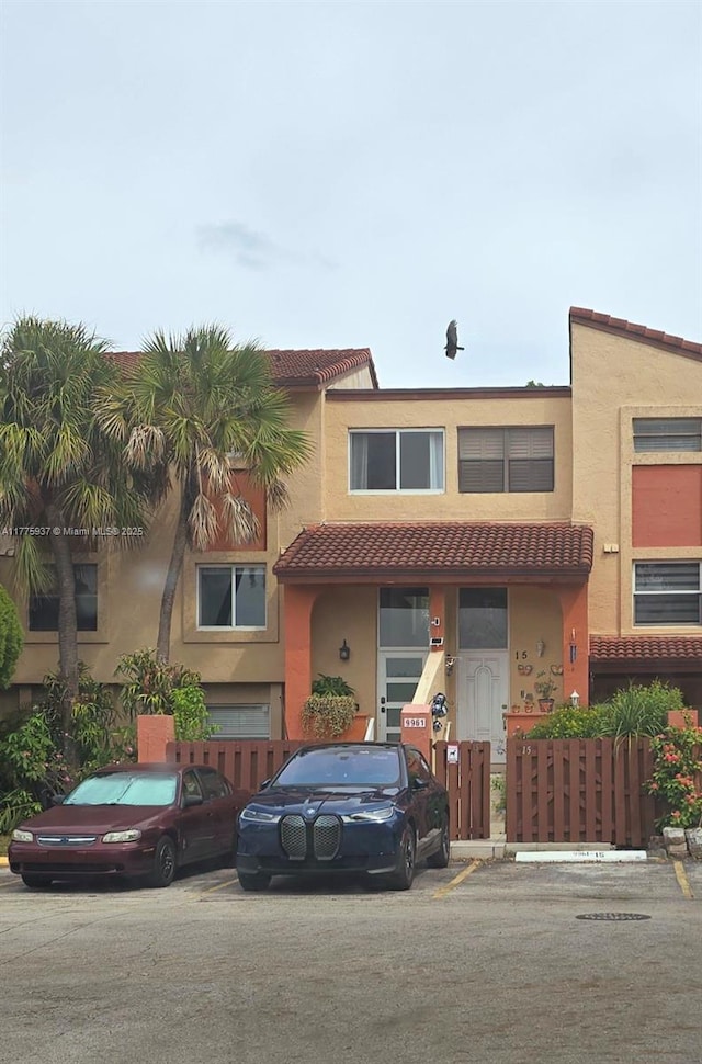 9907 NW 9th St Cir Unit 15-20, Miami, FL 33172 - multi unit property with uncovered parking, a tiled roof, stucco siding, and fence