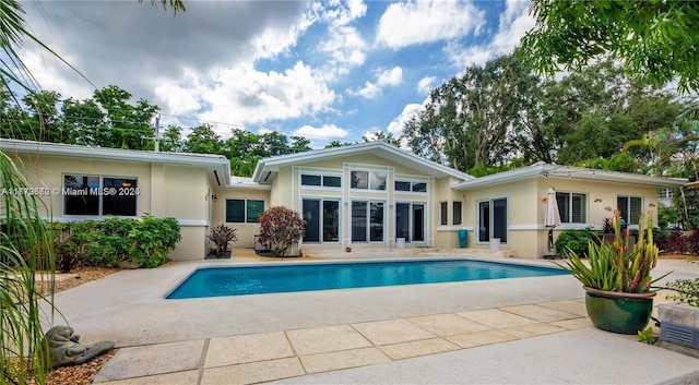 1001 S Alhambra Cir, Coral Gables, FL 33146 - back of property with stucco siding, a patio, and an outdoor pool