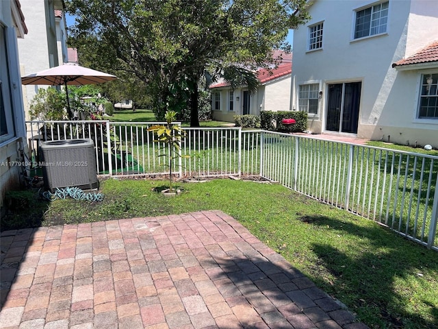 view of yard with a patio, fence, and central AC