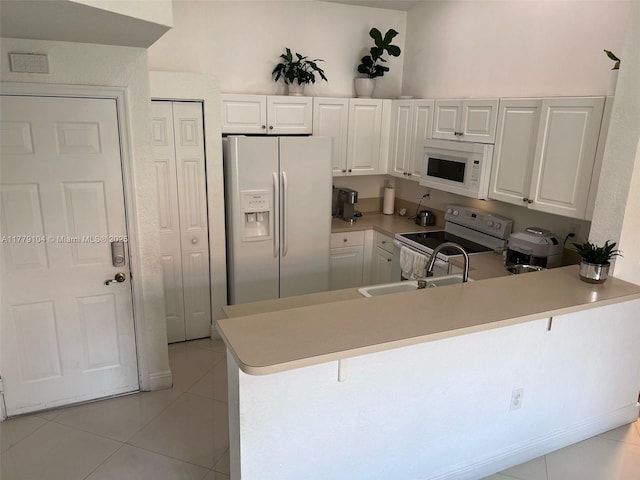 18769 SW 28th St, Miramar, FL 33029 - kitchen with white appliances, a sink, light tile patterned floors, a peninsula, and a kitchen breakfast bar