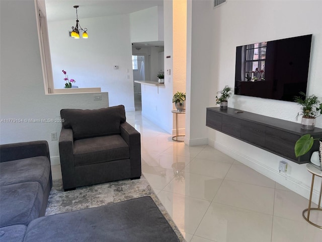 living room featuring light tile patterned floors, baseboards, a chandelier, and visible vents