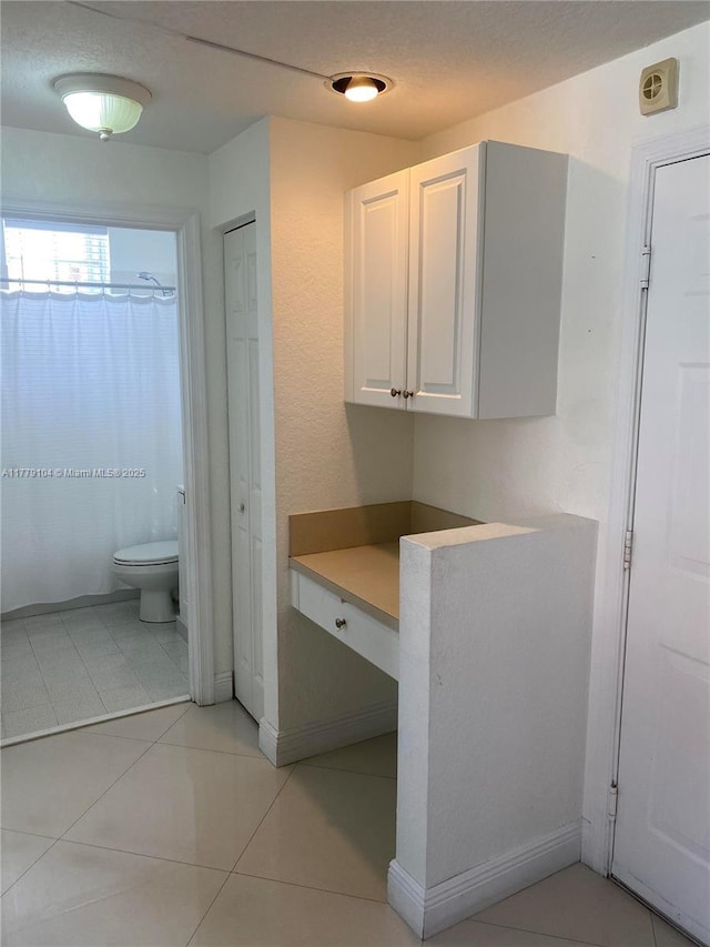 full bath featuring tile patterned floors, toilet, a shower with shower curtain, and a textured ceiling