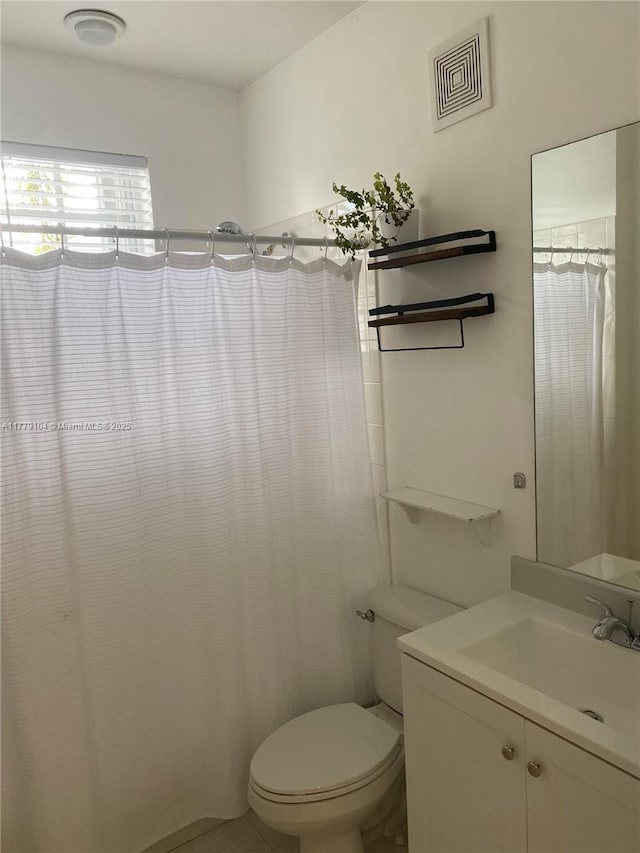 full bath with toilet, vanity, and visible vents