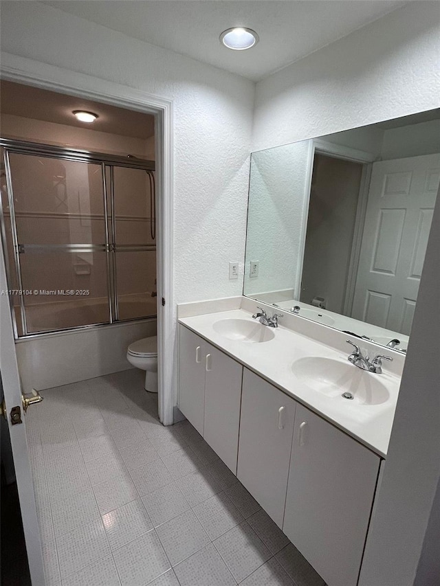 18769 SW 28th St, Miramar, FL 33029 - full bath with toilet, double vanity, a textured wall, and bath / shower combo with glass door