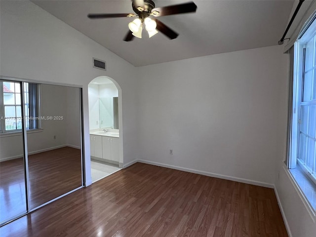18769 SW 28th St, Miramar, FL 33029 - unfurnished bedroom featuring wood finished floors, arched walkways, lofted ceiling, baseboards, and a ceiling fan