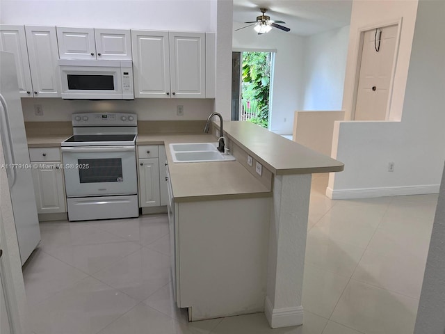 18769 SW 28th St, Miramar, FL 33029 - kitchen with white appliances, a sink, a peninsula, and light countertops