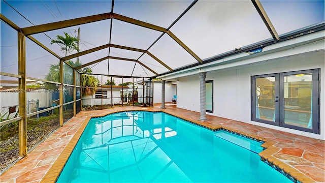 view of pool with a patio area, glass enclosure, and a fenced in pool