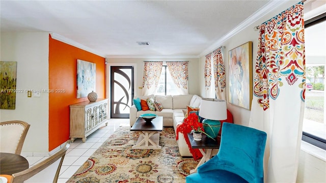 living room with visible vents, baseboards, ornamental molding, and light tile patterned flooring
