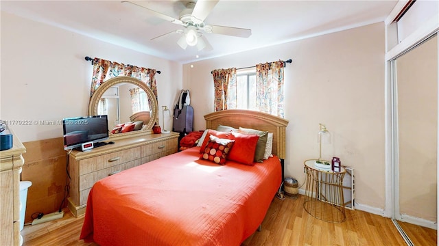 bedroom with light wood-style flooring, baseboards, and a ceiling fan
