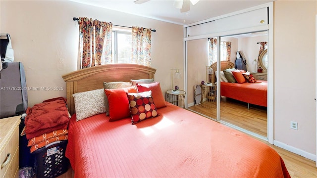 bedroom with a closet, baseboards, a ceiling fan, and wood finished floors
