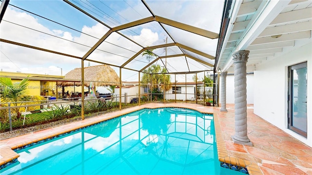 outdoor pool featuring a patio area, fence, and a lanai