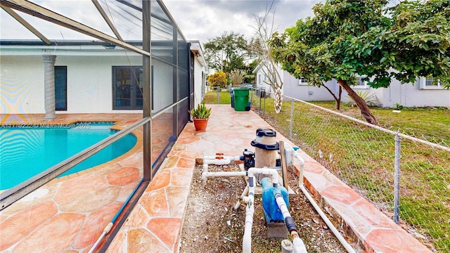 view of swimming pool featuring a yard, glass enclosure, a patio, fence, and a fenced in pool