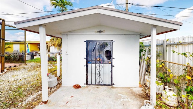 view of outdoor structure featuring fence and an outbuilding