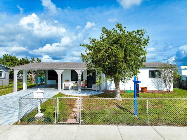 view of front of property with a fenced front yard, stucco siding, a front yard, a gate, and driveway
