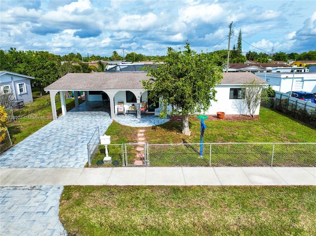 ranch-style home with a fenced front yard, stucco siding, a front lawn, a gate, and decorative driveway