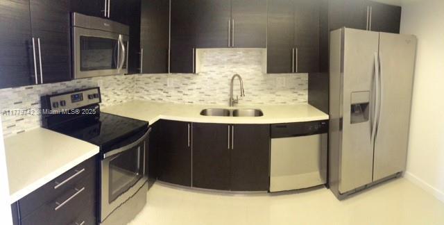 kitchen with a sink, light countertops, tasteful backsplash, and stainless steel appliances