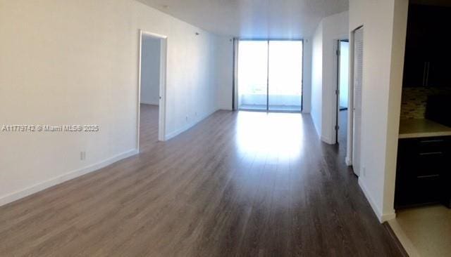 unfurnished room with baseboards and wood finished floors