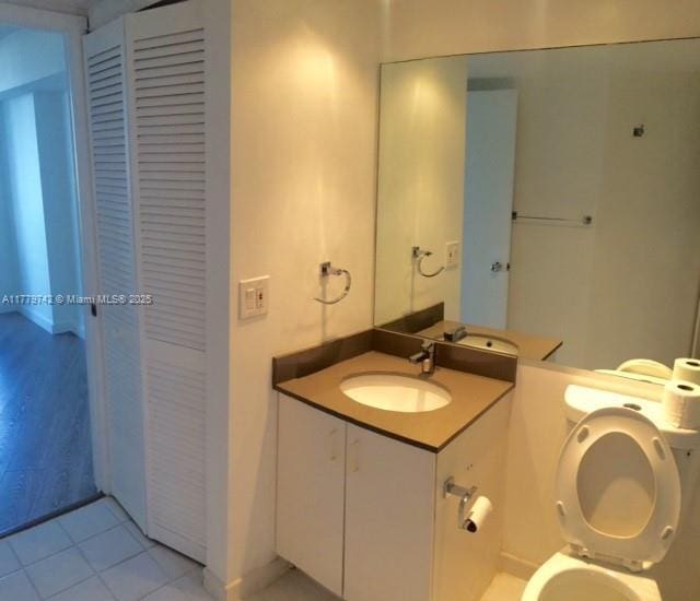 bathroom with tile patterned flooring, toilet, and vanity