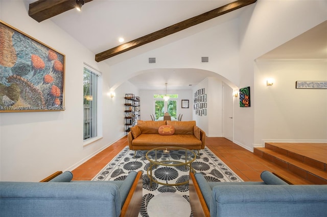 tiled living room with arched walkways, beamed ceiling, and visible vents