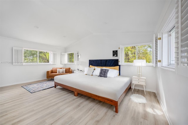 bedroom featuring wood finished floors, baseboards, ornamental molding, and lofted ceiling