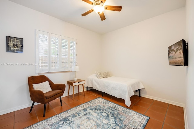 tiled bedroom featuring baseboards and a ceiling fan