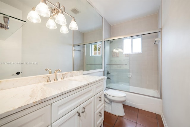 bathroom with visible vents, toilet, vanity, shower / bath combination with glass door, and tile patterned flooring