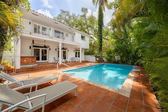 pool with a patio, french doors, and ceiling fan