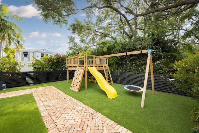view of playground featuring fence and a lawn