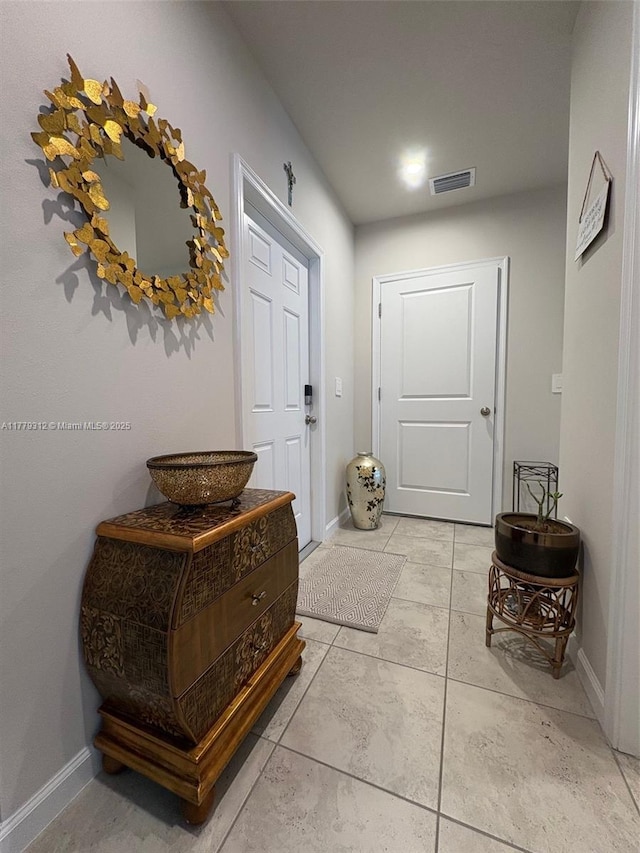 doorway to outside featuring baseboards and visible vents