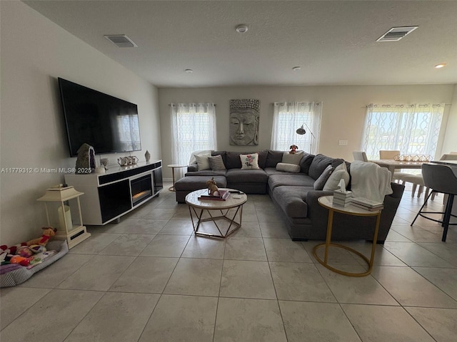 living room featuring light tile patterned floors and visible vents