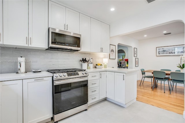 2019 SW 17th Ter, Miami, FL 33145 - kitchen featuring appliances with stainless steel finishes, light countertops, a peninsula, tasteful backsplash, and recessed lighting