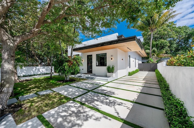 back of property featuring stucco siding and fence