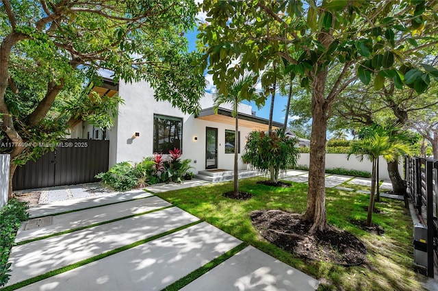 view of front of property featuring stucco siding and fence