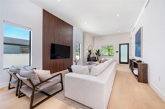living room featuring baseboards, recessed lighting, and light wood-style floors