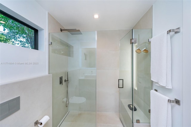 bathroom with a stall shower and tile patterned flooring