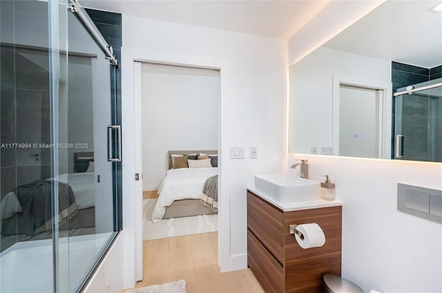 full bath with wood finished floors, connected bathroom, vanity, and a shower with shower door